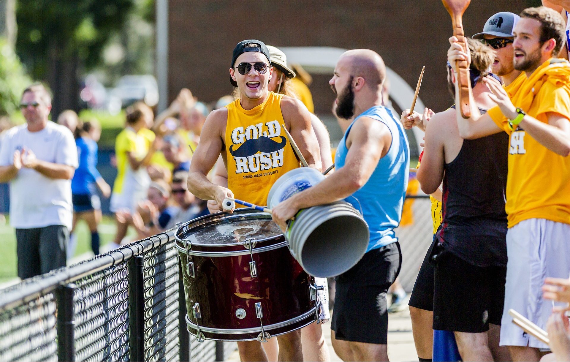 Student section cheering and playing drums at a Cougars soccer game