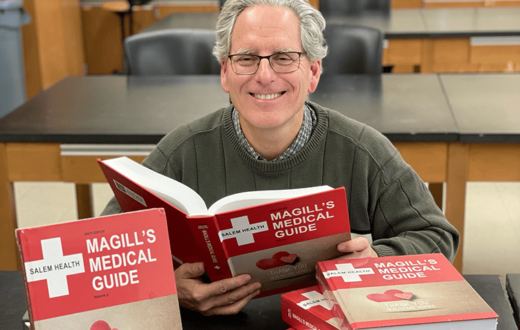 Professional Michael Buratovich, Ph.D. posed with the Magill Medical Guide, 9th edition.