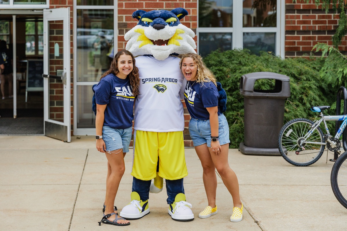 Two students posing with Blue the Cougar.