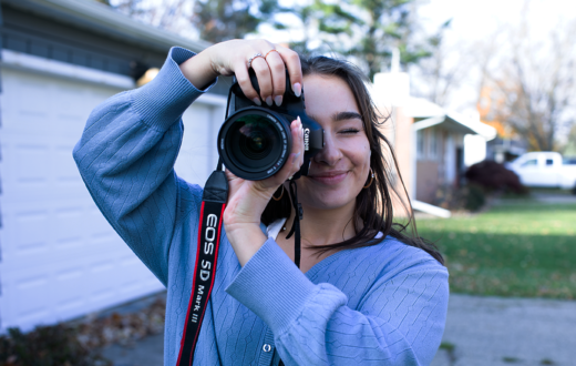 Student photographer Bella Chirco holding the camera up to her face