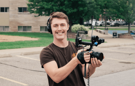 Will Urban holding a film camera smiling for the camera